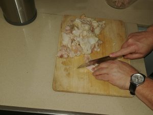 Slicing chicken skin and fat for making into schmaltz.